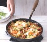 Breakfast hash in a pan with eggs