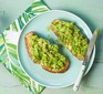 Smashed avocado on sourdough toast with knife on plate