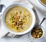 Celeriac soup in a bowl topped with toasted hazelnut crumble