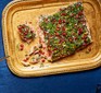 Confit salmon with tahini, pistachio & herb crust served on a gold tray