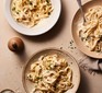 Three plates of creamy garlic pasta