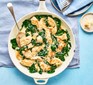 Creamy spinach chicken in a pan with a spoon