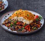 Harissa-crumbed fish with lentils, olives & peppers served on a plate