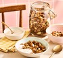 Healthy homemade granola in a jar alongside a bowl