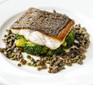 A fillet of pan-fried sea bass on a bed of broccoli and capers