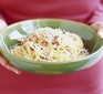 Bowl of spaghetti carbonara with grated parmesan