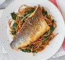 White fish with sesame noodles and spinach served on a white plate